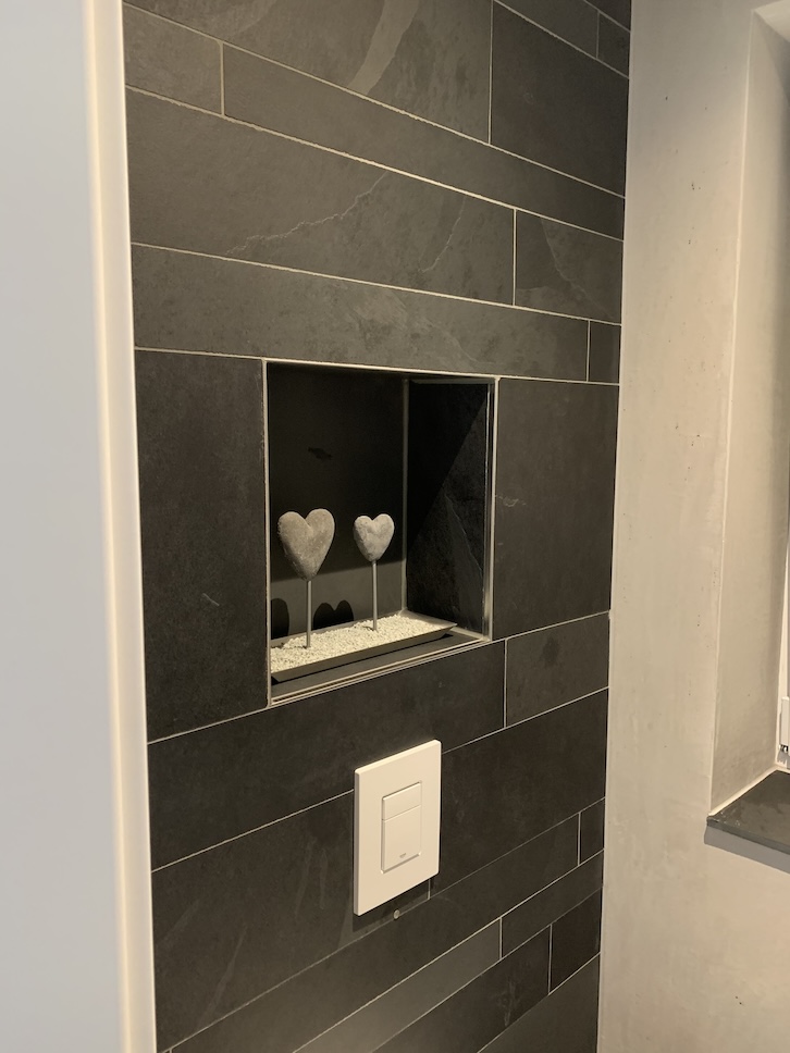 Dekoratives Badezimmer mit dunklen Fliesen